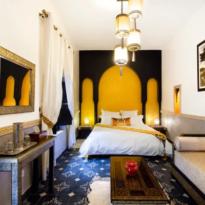 Suite MEDINA Située au 1er étage, décorée aux couleurs de Marrakech, équipée d'un lit King size, d'un petit salon, de murs travaillés au Tadelak et de carreaux ciment, ainsi que d'un balcon attenant avec vue sur piscine, et d'une salle de bain privée.